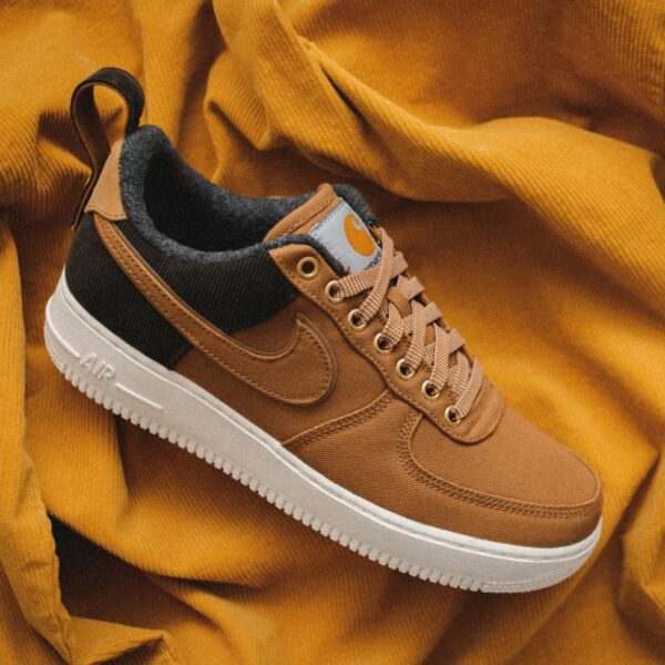 brown Nike sneaker on yellow textile